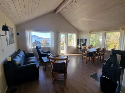 a living room with a couch and a table and chairs at Færøya 49 in Nekkøyane