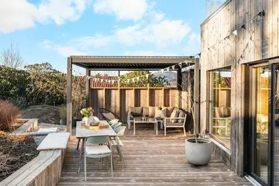 a patio with a table and chairs on a wooden deck at Stay in The Hollywood Hills of Bergen with Breathtaking Views in Bergen