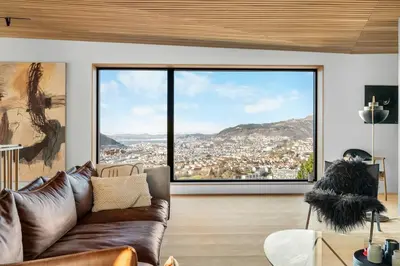 a living room with a couch and a large window at Stay in The Hollywood Hills of Bergen with Breathtaking Views in Bergen