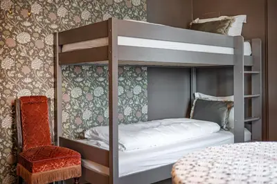 a bedroom with a bunk bed and a chair at Jugend 1904 in Ålesund