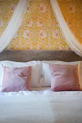 a bedroom with a bed with pink pillows at Jugend 1904 in Ålesund