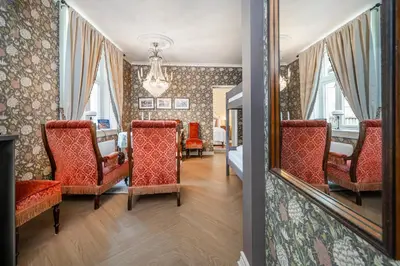 a room with chairs and a bed and a mirror at Jugend 1904 in Ålesund