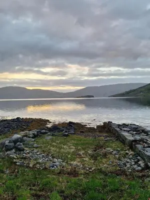 a large body of water with mountains in the background at Villa ved sjøen og fjellene in Myklebostad