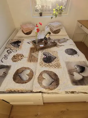 two beds with a blanket with birds on it at Adventure house Katrine in Mosvik