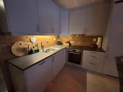 a kitchen with white cabinets and a sink at Apartment in Myrkdalen Voss in Vossevangen