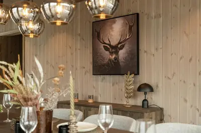 a dining room with a picture of a deer on the wall at Hydla Mountain Lodge in Stryn