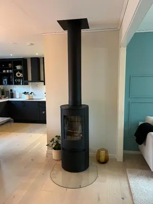 a black stove in a living room with a kitchen at Bergen - Home, Close to Airport and the city in Bergen