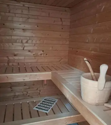 a wooden sauna with a bucket and paddles in it at cozy house with boat dock, sauna - FJORDTID in Rubbestadneset