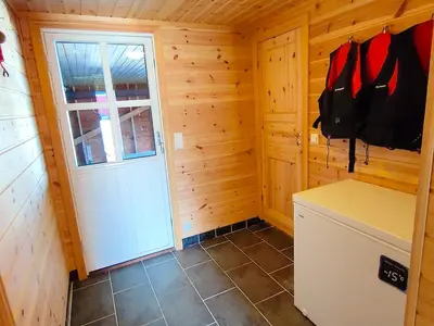 a kitchen with a door in a wooden cabin at cozy house with boat dock, sauna - FJORDTID in Rubbestadneset