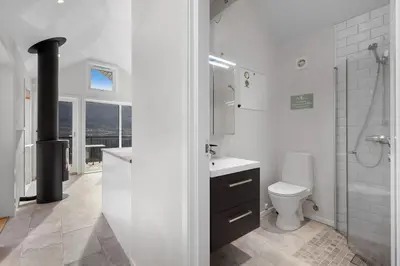 a white bathroom with a toilet and a sink at Stryn Fjord Cottage Faleide in Stryn
