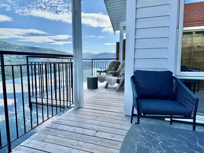 a chair on a porch with a view of the water at Stryn Fjord Cottage Faleide in Stryn