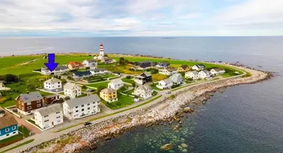 an aerial view of a small town with a lighthouse at Nesheim in Alnes