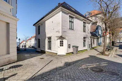 an old white house on a street in a city at Skuteviken House in Bergen