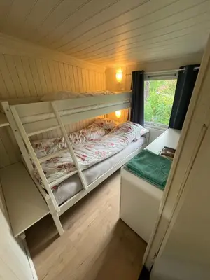 a small bedroom with a bunk bed and a window at #Beautiful outdoor area and cozy small cottage# in Fotlandsvåg