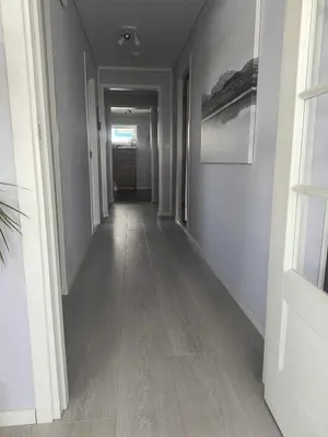 a hallway with white walls and a wooden floor at Skjærgårdsidyll in Askøy