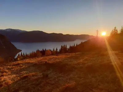 a sunset on a hill with a view of a lake at Støl ved Sognefjorden in Berge