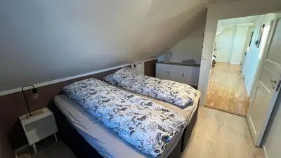 a bedroom with a bed with blue and white sheets at Villa with heated pool and magnificent view in Bergen