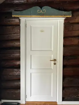 a white door in front of a wooden wall at Tuddal Hyttegrend, GAMLESTUGU, Telemark in Tuddal