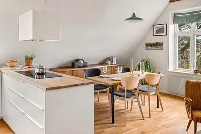 a kitchen and dining room with a table and chairs at Design Apartment by Bryggen - View & Location in Bergen