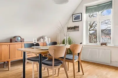 a dining room with a wooden table and chairs at Design Apartment by Bryggen - View & Location in Bergen