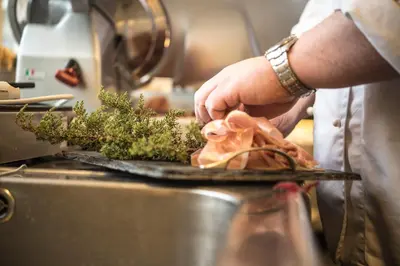 a chef preparing food on a plate in a kitchen at Lemonsjø Fjellstue og Hyttegrend in Randsverk