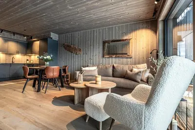 a living room with a couch and a table at Modern and practical ski in & out apartment in Kyrkjebøen