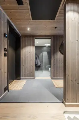 a hallway with wood paneled walls and a bathroom at Modern and practical ski in & out apartment in Kyrkjebøen