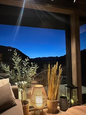 a window with potted plants and a view of the mountains at Modern and practical ski in & out apartment in Kyrkjebøen