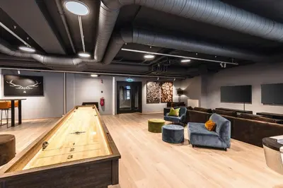 a bowling alley with a ping pong table in a room at Modern and practical ski in & out apartment in Kyrkjebøen