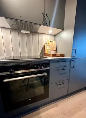 a kitchen with a black oven in a kitchen at Modern and practical ski in & out apartment in Kyrkjebøen