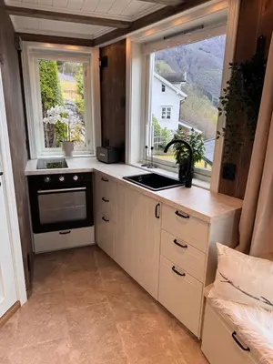 a small kitchen with a sink and a window at Fjord Cabin with Panoramic View & Private Balcony in Luster