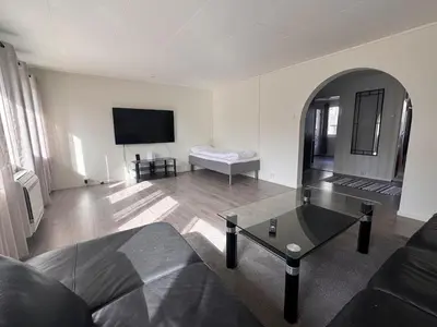 a living room with a couch and a table at Trolltunga Apt for up to 5 people with balcony in Tysso