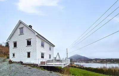 a white house on the side of a body of water at Pet Friendly Home In Nedre Vats in Åmsosen