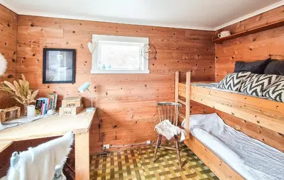a bedroom with wooden walls and a bed and a desk at Pet Friendly Home In Nedre Vats in Åmsosen