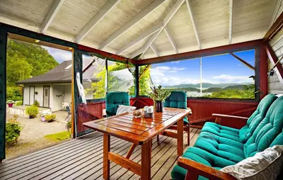 a screened in porch with a wooden table and chairs at Nice Home In Lundegrend With Wifi in Grimsland