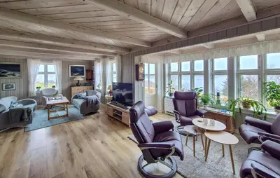 a living room with chairs and a tv and windows at Awesome Home In Bekkjarvik in Bekkjarvik