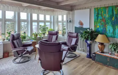 a salon with purple chairs in a room with windows at Awesome Home In Bekkjarvik in Bekkjarvik