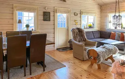 a living room with a couch and a table at Lovely Home In Straumgjerde in Brunstad