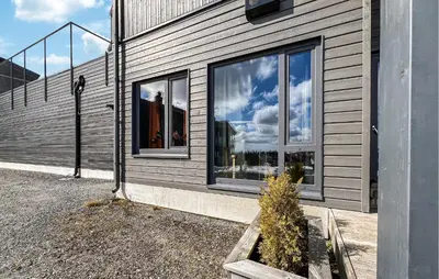 a building with windows and a plant in a planter at 2 Bedroom Awesome Apartment In Sjusjøen in Sjusjøen