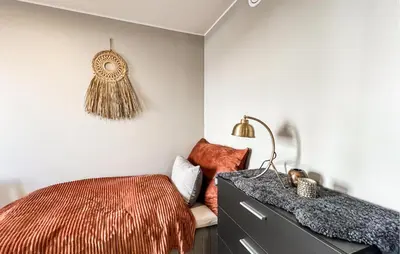a bedroom with a bed and a dresser with a lamp at 2 Bedroom Awesome Apartment In Sjusjøen in Sjusjøen