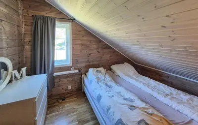 a bed in a wooden room with a window at 4 Bedroom Stunning Home In Hebnes in Hebnes