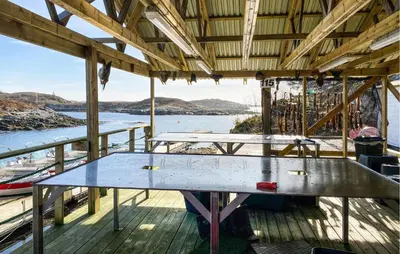 a table on a deck with a view of the water at Gorgeous Home In Kverva With Wifi in Kverva