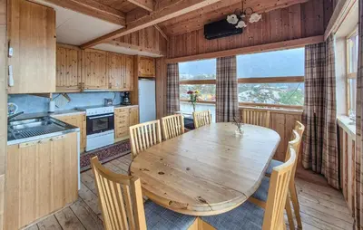 a kitchen with a wooden table and chairs at Lovely Home In Masfjordnes With Sauna in Masfjorden