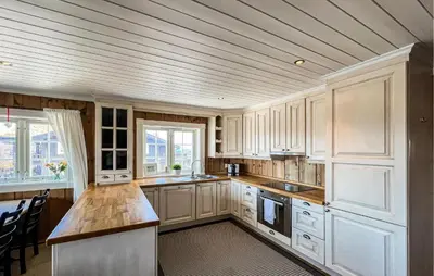 a kitchen with white cabinets and a wooden ceiling at Stunning Apartment In Røn With Sauna in Ron