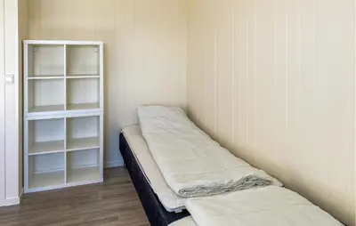 a room with two beds and a book shelf at Nice Home In Kverva With Wifi in Kverva