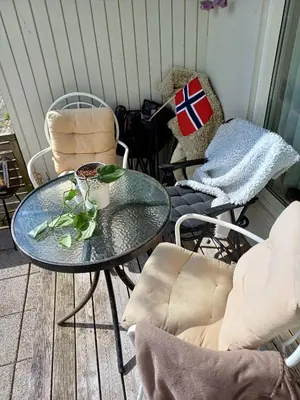a table and chairs on a porch with a flag on it at Sentrums nærsentrum tur og sjø på hundvåg in Lii