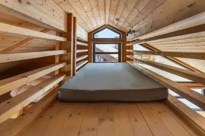 a bed in the middle of a room with wooden floors at Liapark in Ål