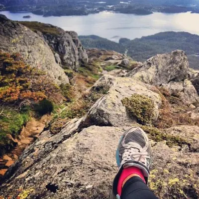 a person standing on top of a mountain at Seaside Cabin with panoramic view in Bømlo