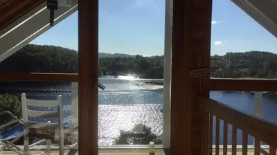 a view of a lake from a porch at Seaside Cabin with panoramic view in Bømlo