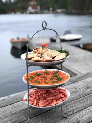 three plates of food on a table next to the water at Stay where the mountains begin in Bømlo